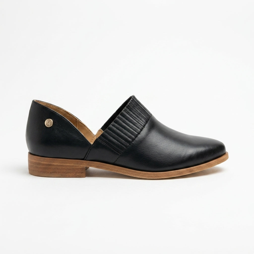 Single black leather slip-on oxford shoe with a wood-look sole, side cutout, and pleated elastic detail.